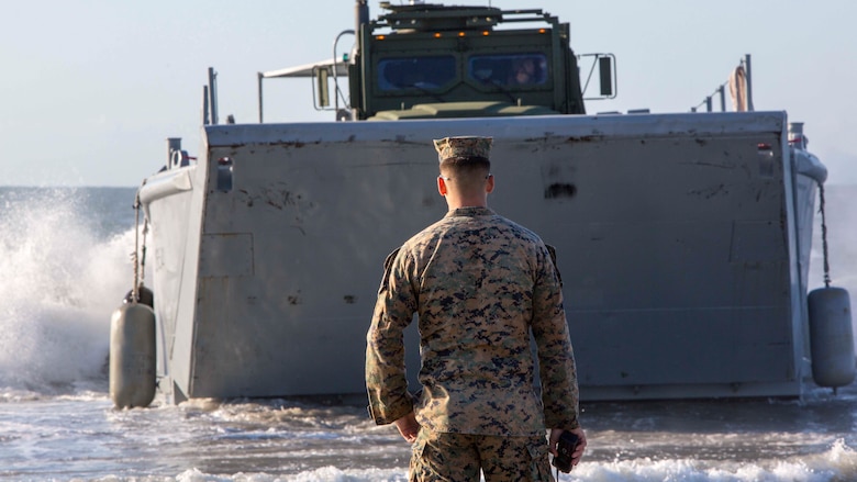 First Lt. James A. Teasdale supervises an Army Landing Craft Mechanized-8 boat carrying Marine personnel and equipment during a beach operations group exercise at Onslow Beach, N.C., March 30, 2017. The training provided Marines the opportunity to work with Soldiers as part of field exercise Bold Bronco 17. Teasdale is platoon commander with Combat Logistics Battalion 8, 2nd Marine Logistics Group. 