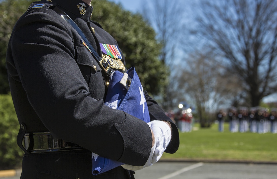 A U.S. Marine with Marine Barracks Washington holds a flag during the memorial service for retired Lt. Gen. Lawrence F. Snowden at Marine Corps Base Quantico, Va., April 8, 2017. Snowden served in World War II, the Korean War, Vietnam War, and was the senior survivor of the Battle of Iwo Jima.