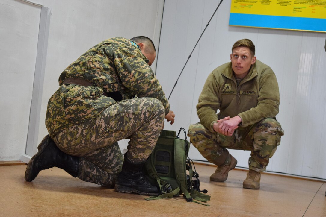 Staff Sgt. Joshua Atanovich, 149th Military Engagement Team, watches the time as a Kazakhstani soldier from the Kazakhstan Peacekeeping Battalion prepares his radio for a commo check during Steppe Eagle Koktem, Apr. 4, 2017, at Illisky Training Center, Kazakhstan. Tactical communications is one of the military-to-military engagements that occur during Steppe Eagle Koktem.