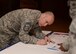 U.S. Air Force Chief Master Sgt. Curtis Stanley, 100th Air Refueling Wing command chief, fills out the first donation from RAF Mildenhall to the Air Force Assistance Fund for the fiscal year April 7, 2017, on RAF Mildenhall, England. The AFAF is an annual effort to raise funds for the charitable affiliates that provide support to Air Force active duty-members, retirees, reservists, guard and their dependents when needed. (U.S. Air Force Photo by Airman 1st Class Tenley Long)