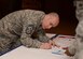 U.S. Air Force Chief Master Sgt. Curtis Stanley, 100th Air Refueling Wing command chief, fills out the first donation from RAF Mildenhall to the Air Force Assistance Fund for the fiscal year April 7, 2017, on RAF Mildenhall, England. The AFAF is an annual effort to raise funds for the charitable affiliates that provide support to Air Force active duty-members, retirees, reservists, guard and their dependents when needed. (U.S. Air Force Photo by Airman 1st Class Tenley Long)