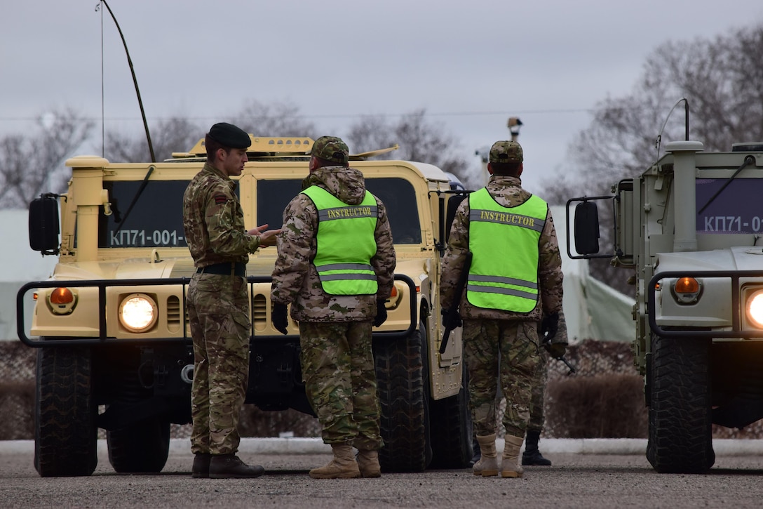 A U.K. Soldier with the British Army's 1st Battalion, The Rifles, 160 Brigade, discusses options for using vehicles during crowd control with a Kazakhstani instructor from the Kazakhstan Peacekeeping Battalion during Steppe Eagle Koktem, Apr. 3, 2017, at Illisky Training Center, Kazakhstan.