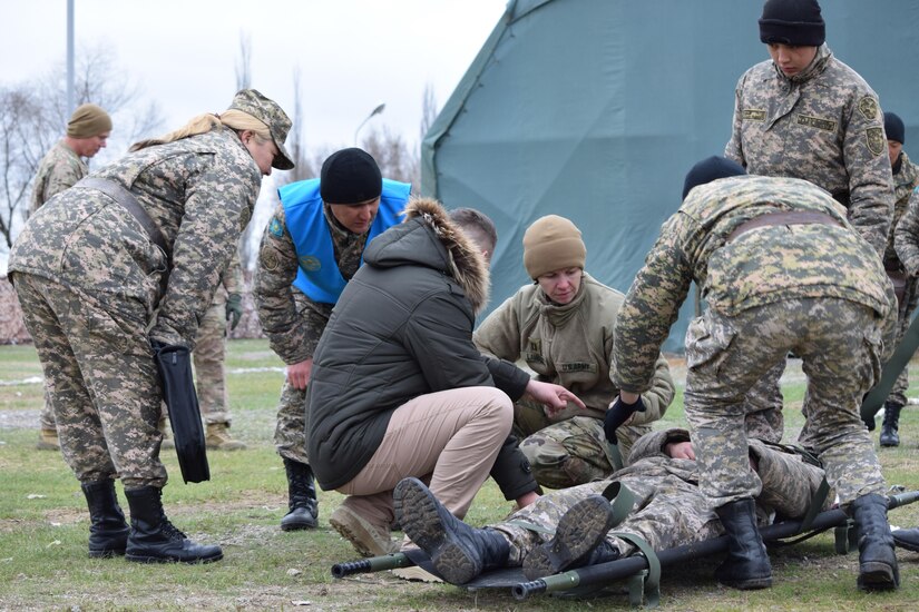 A U.S. Army Soldier with 31st Combat Support Hospital shows a Kazakhstani medic with the Kazakhstan Peacekeeping Battalion how to properly secure a patient in a litter during Steppe Eagle Koktem, Apr. 3, 2017 at Illisky Training Center, Kazakhstan.