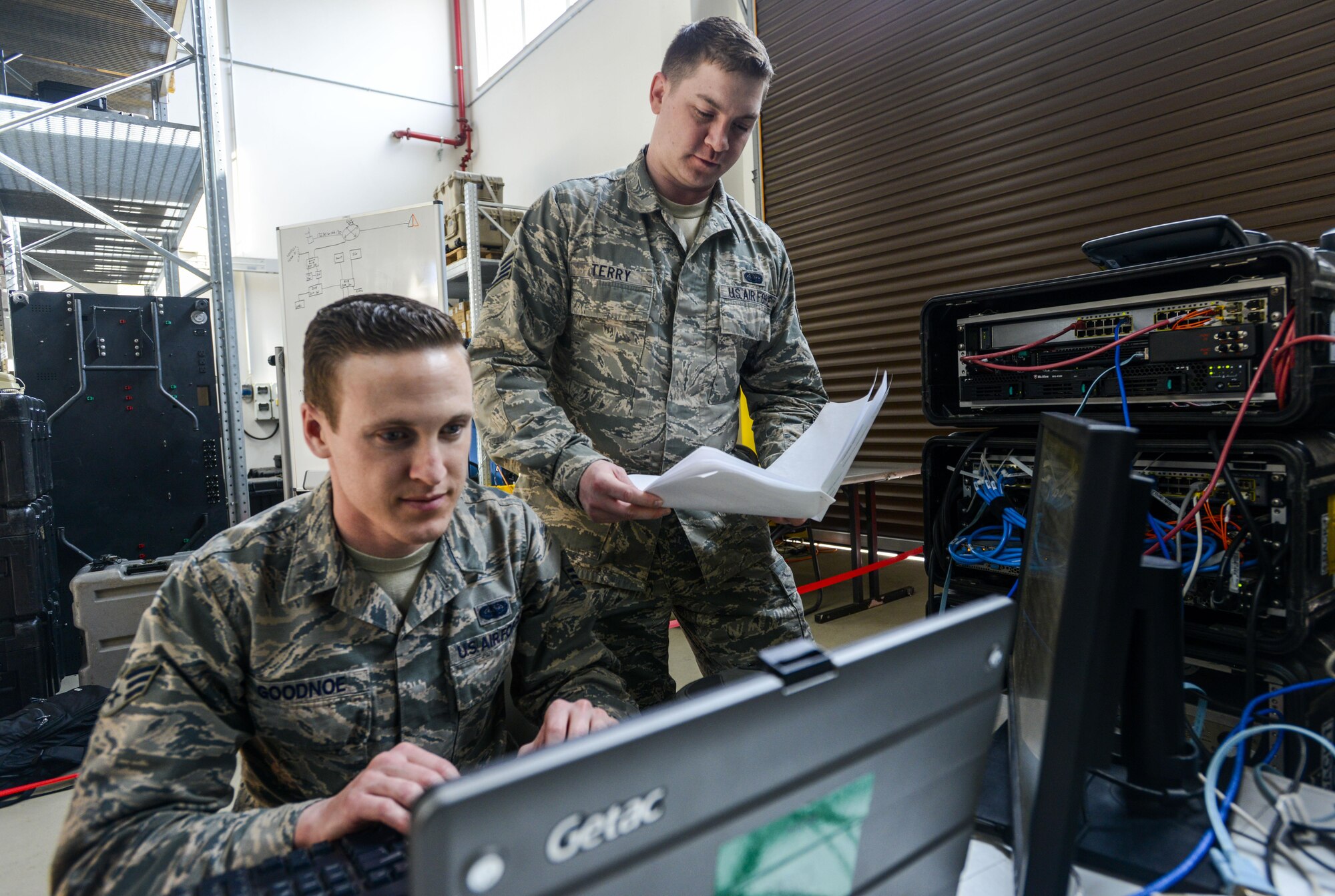 U.S. Air Force Senior Airman Thomas Goodnoe, left, 1st Combat Communications Squadron tactical network operations technician, and Staff Sgt. Darryl Terry, right, 1st CBCS cyber transport supervisor, review their systems against their technical guides during cyber security audit March 16, 2017, on Ramstein Air Base, Germany. The U.S. Army Cyber Protection Brigade’s 201st Cyber Protection Team audited the 1st CBCS’ deployable network control centers, which are tactical communications kits that allow 1st CBCS operators to set up and manage secure communications in deployed locations. (U.S. Air Force photo/Staff Sgt. Timothy Moore)