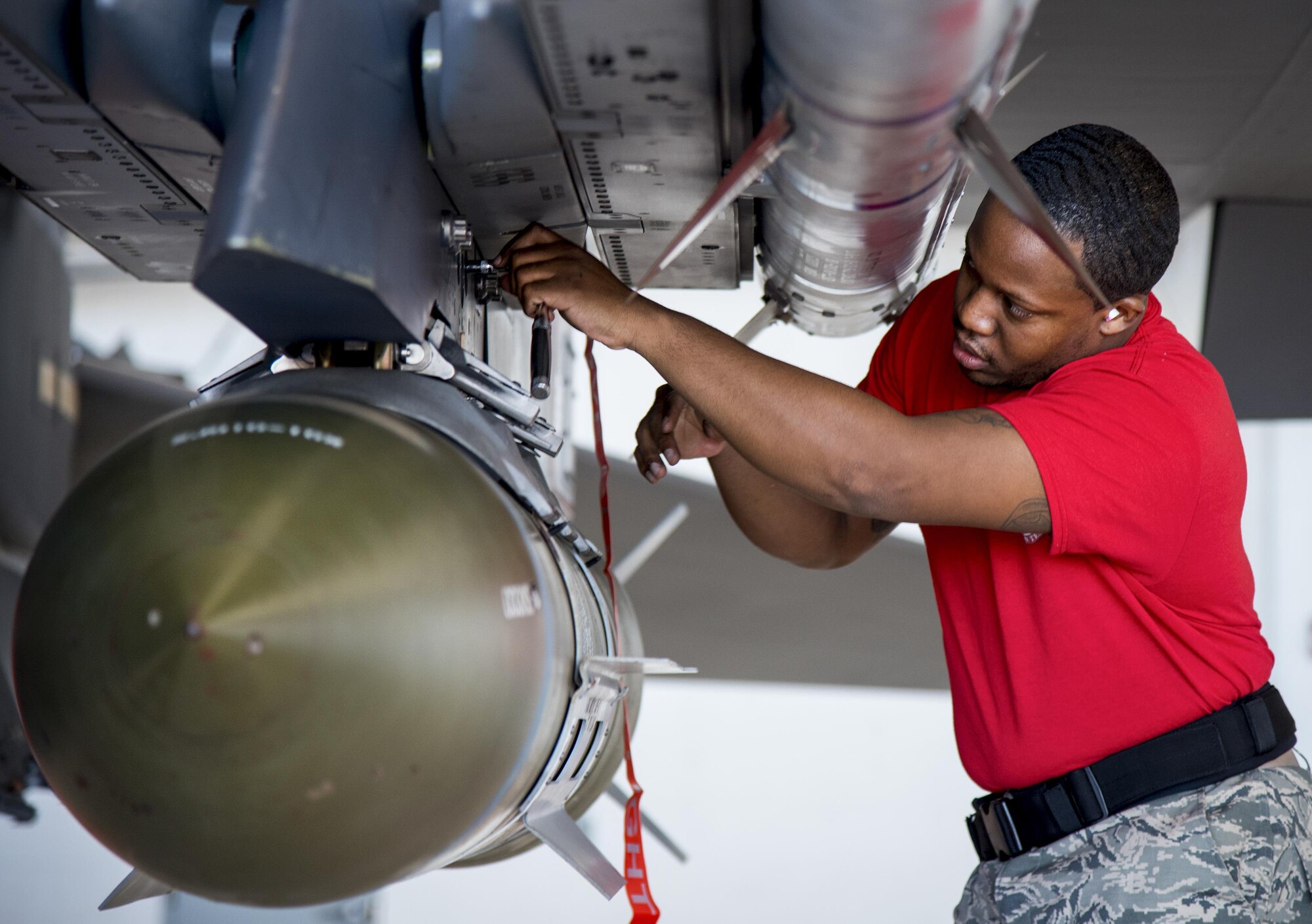 Senior Airman Troy Carpenter, 96th Aircraft Maintenance Squadron Red, secures a guided-bomb-unit-31 on an F-15 during the Team Eglin weapons load competition April 7 at Eglin Air Force Base, Fla.  Teams from the 96th Test Wing and 33rd Fighter Wing competed to see who could load up two weapons onto their designated aircraft the quickest and with the fewest errors.  The 33rd FW team repeated as base champion.  (U.S. Air Force photo/Samuel King Jr.)