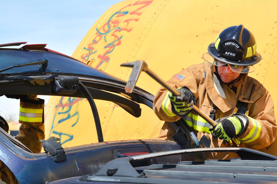 Air Force Senior Airman Michael Newcomer uses a Halligan tool  to break a rear hatch hinge during a heavy vehicle extrication exercise at Eastern Oklahoma County Technology Center in Choctaw, Okla., March 31, 2017. Newcomer is a firefighter assigned to the 507th Civil Engineer Squadron. Air Force photo by Master Sgt. Grady Epperly 