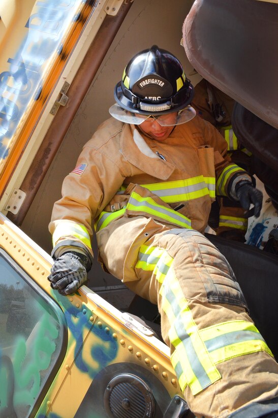 Air Force Senior Airman Teyler Williston exits a wrecked school bus during a heavy vehicle extrication exercise at Eastern Oklahoma County Technology Center in Choctaw, Okla., March 31, 2017. Williston is a firefighter assigned to the 507th Civil Engineer Squadron. Air Force photo by Master Sgt. Grady Epperly