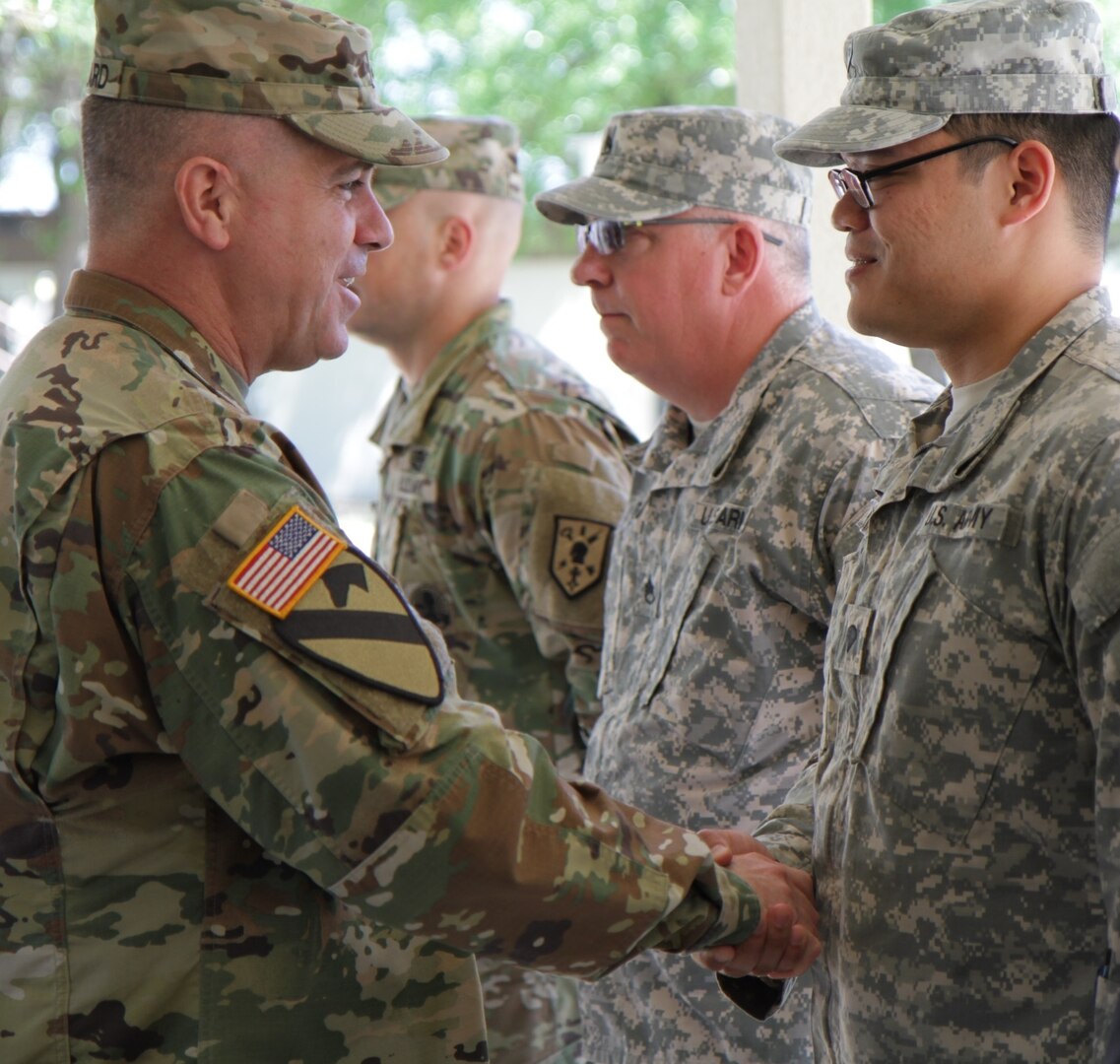 Army Maj. Gen. Christopher Ballard, commander, U.S. Army Intelligence and Security Command, presents the  Intelligence and Security Command Coin to Spc. Mark Abrian, a Soldier with 505th Military Intelligence Brigade (Theater), March 31 while at Joint Base San Antonio-Camp Bullis. 
