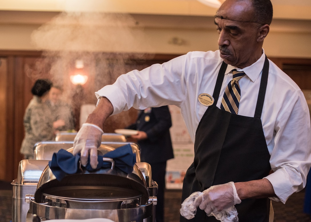 Tommy Henderson, The Club at Andrews general manager, unveils a food buffet during the annual National Prayer Luncheon at Joint Base Andrews, Md., April 4, 2017. The event consisted of group prayer, a meal, music by the U.S. Air Force Band, and a speech made by Brig. Gen. J. Steven Chisolm, Air National Guard Assistant to the U.S. Air Force Chief of Chaplains. (U.S. Air Force photo by Senior Airman Jordyn Fetter)