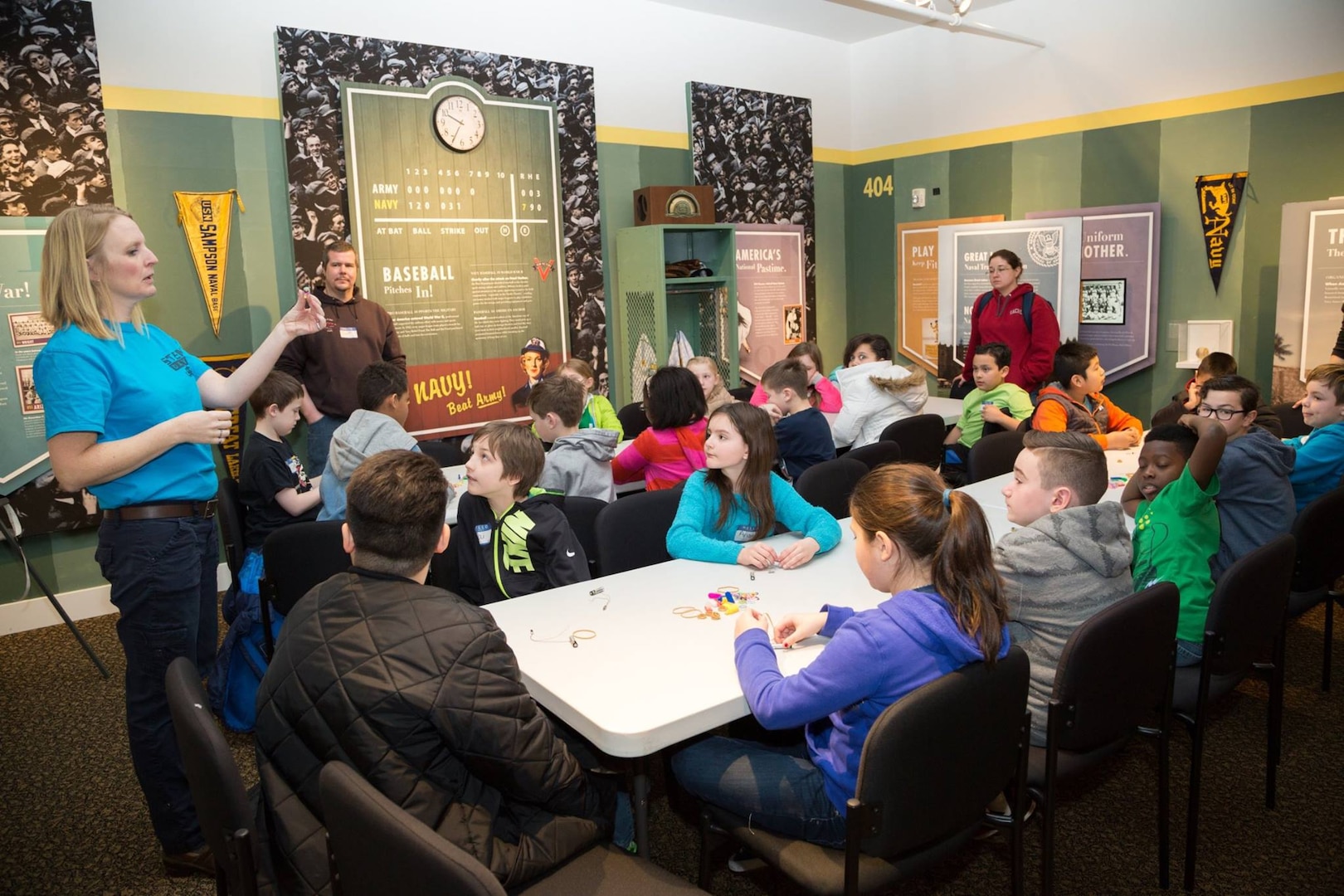 PSNS & IMF Science, Technology, Engineering, and Math Outreach Coordinator Corinne Beach shows students from Pinecrest Elementary School how to use a battery to demonstrate electrical circuitry during a Navy STEM event at the Puget Sound Navy Museum, March 17, 2017, in Bremerton, Washington. Volunteers from PSNS & IMF teamed up with Puget Sound Navy Museum staff to hold a two-day STEM outreach event for local students at the museum March 16-17. (U.S. Navy photo by Zachary Frank, PSNS & IMF photographer)