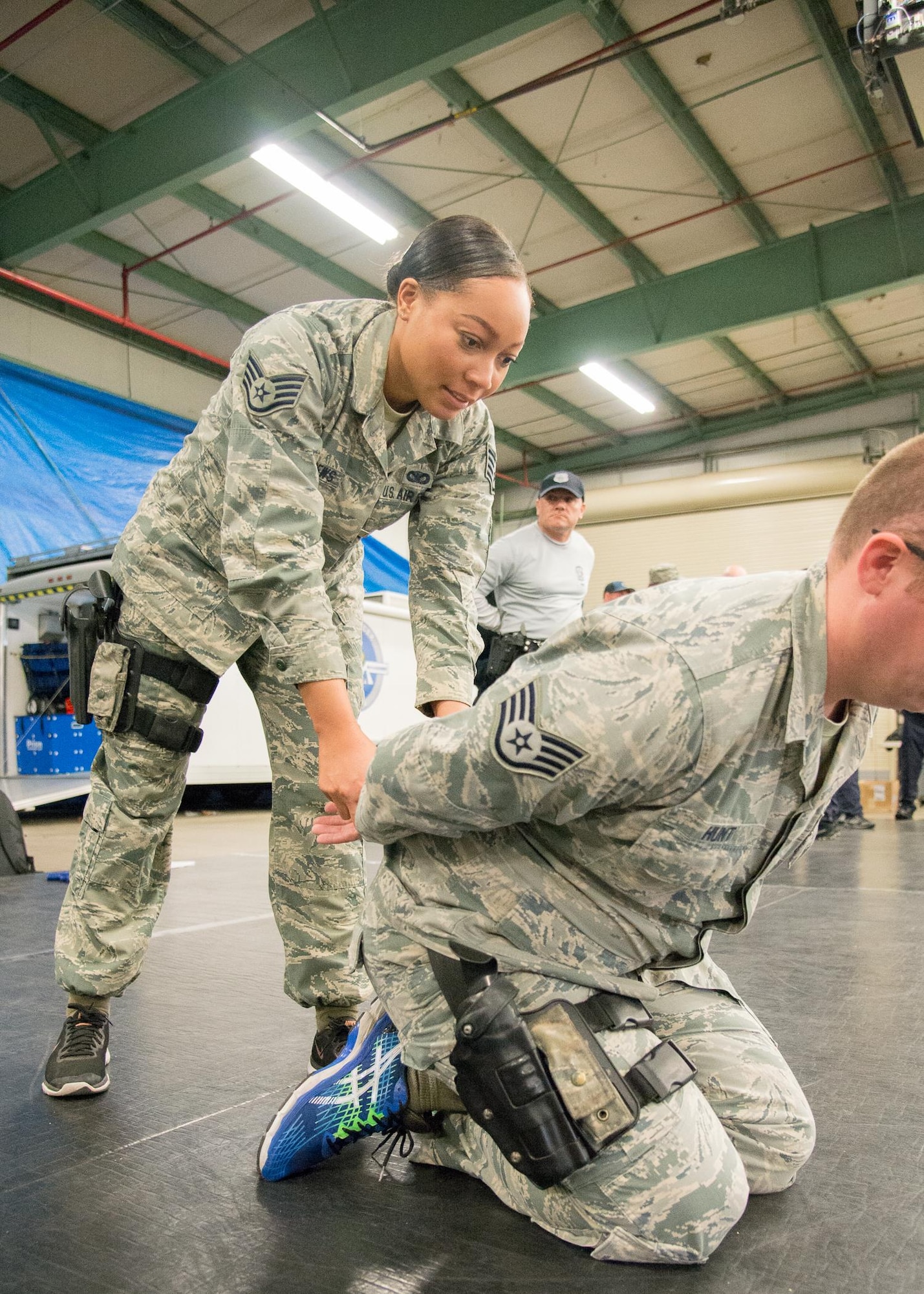 Staff Sgt. Gabriele Matthews, 436th Security Forces Squadron assistant NCO in charge of the commander’s support staff, practices handcuffing a suspect who is in a controlled kneeling position April 6, 2017, at Dover Air Force Base, Del. The technique can help protect an arresting officer against a suspect who displays aggressive behavior or is physically stronger. (U.S. Air Force photo by Mauricio Campino)