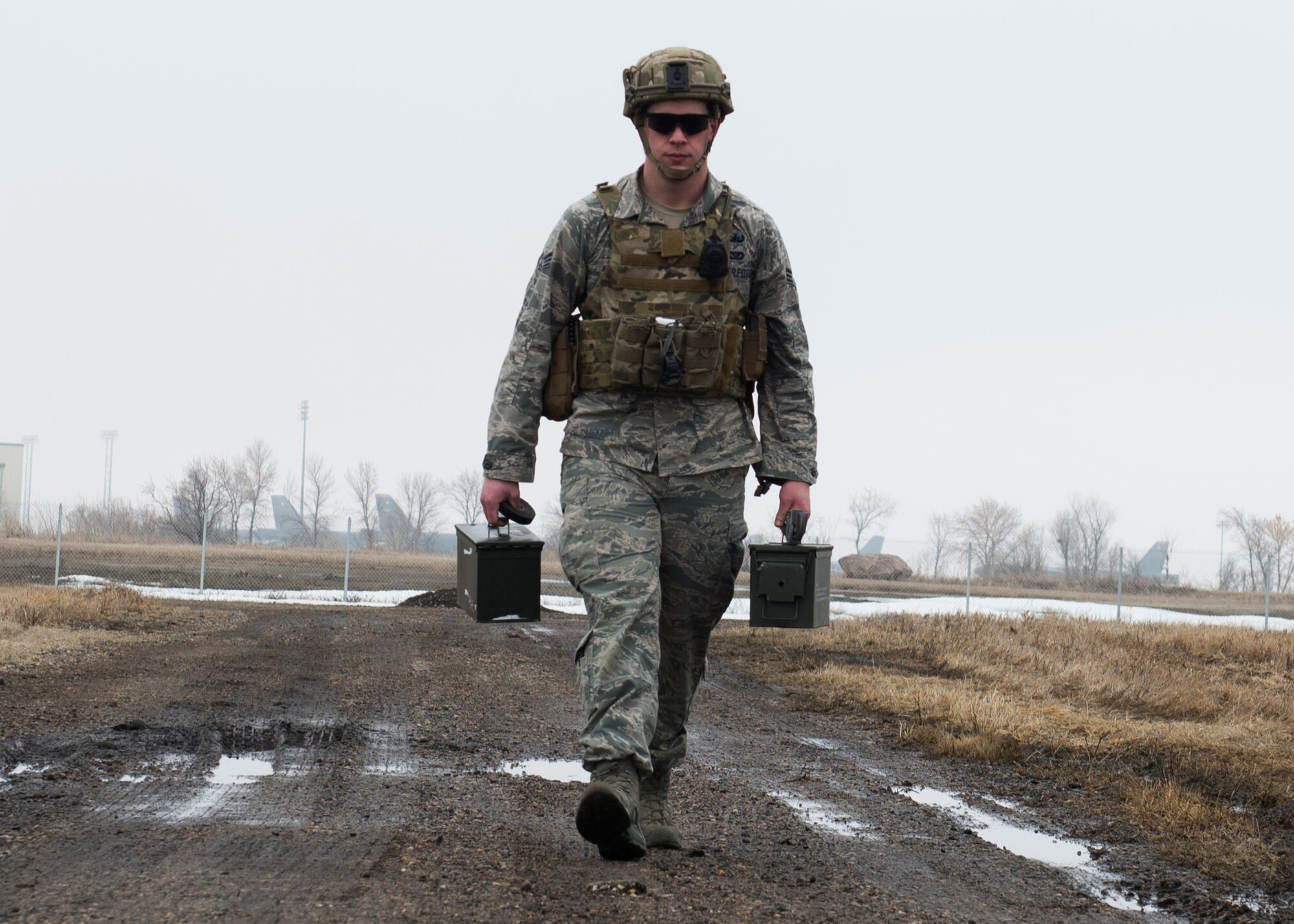 Senior Airman Adam Allen, 5th Civil Engineer Squadron explosive ordnance disposal team leader, carries ammunition cans at Minot Air Force Base, N.D., March 28, 2017. During training, EOD Airmen practiced safely securing inert unexploded ordnance parts to ensure the safety of personnel transporting a UXO. (U.S. Air Force photo/Airman 1st Class Alyssa M. Akers)