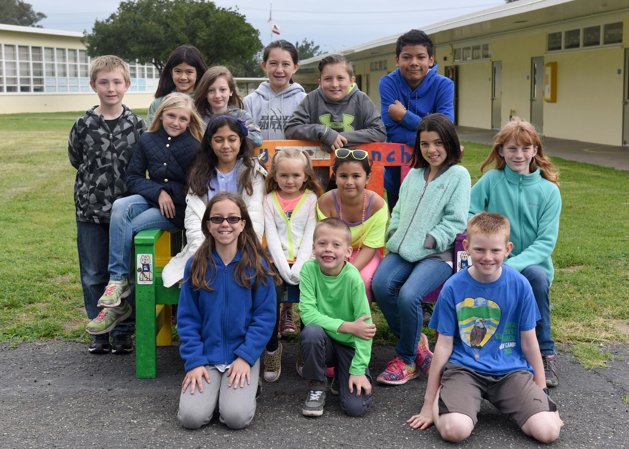 Students from Crestview Elementary school, gather around a Buddy Bench, April 7, 2017, Vandenberg Air Force Base, Calif. Decorated and painted by the students themselves, the Buddy Benches are placed on the playground for any child to sit on, signaling the need of friendship and support. (U.S. Air Force photo by Senior Airman Kyla Gifford/Released)