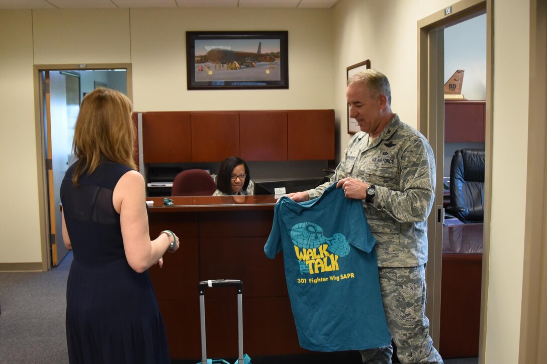 Ms. Laura Loftin, 301st Fighter Wing sexual assault response coordinator, hands out teal t-shirts to Tenth Air Force staff members in order to raise awareness of sexual assault and to empower members to take action in order
to prevent future assaults. This year's SAPR theme is "Protecting our people protects our mission."  (U.S. Air Force photo by Maj. Rodney Ellison)