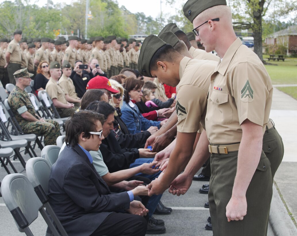 Marines hand ceremonial purple heart pins to family of fallen Marines with 2nd Light Armored Reconnaissance Battalion, 2nd Marine Division during a memorial ceremony at Camp Lejeune, N.C., April 7, 2017. The ceremony honored fallen Marines as well as families and friends of the 2nd LAR community. (U.S. Marine Corps photo by Lance Cpl. Raul Torres) 