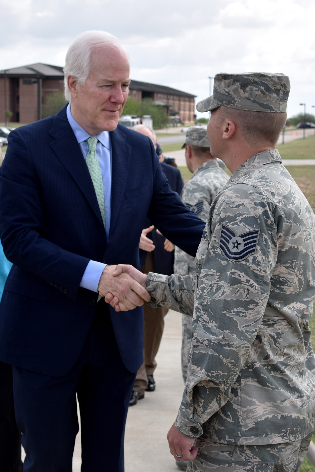 Sen. John Cornyn III, Senate Majority Whip for the 115th Congress, meets U.S. Air Force Tech. Sgt. Aaron Dvorak, 315th Training Squadron geospatial intelligence analysis course chief, before his press conference at the RQ-1 Predator aircraft display on Goodfellow Air Force Base, Texas, April 10, 2017. Dvorak explained to Cornyn how Goodfellow trains intelligence analysts here and how our training ties to the aircraft. (U.S. Air Force photo by Staff Sgt. Joshua Edwards/Released)