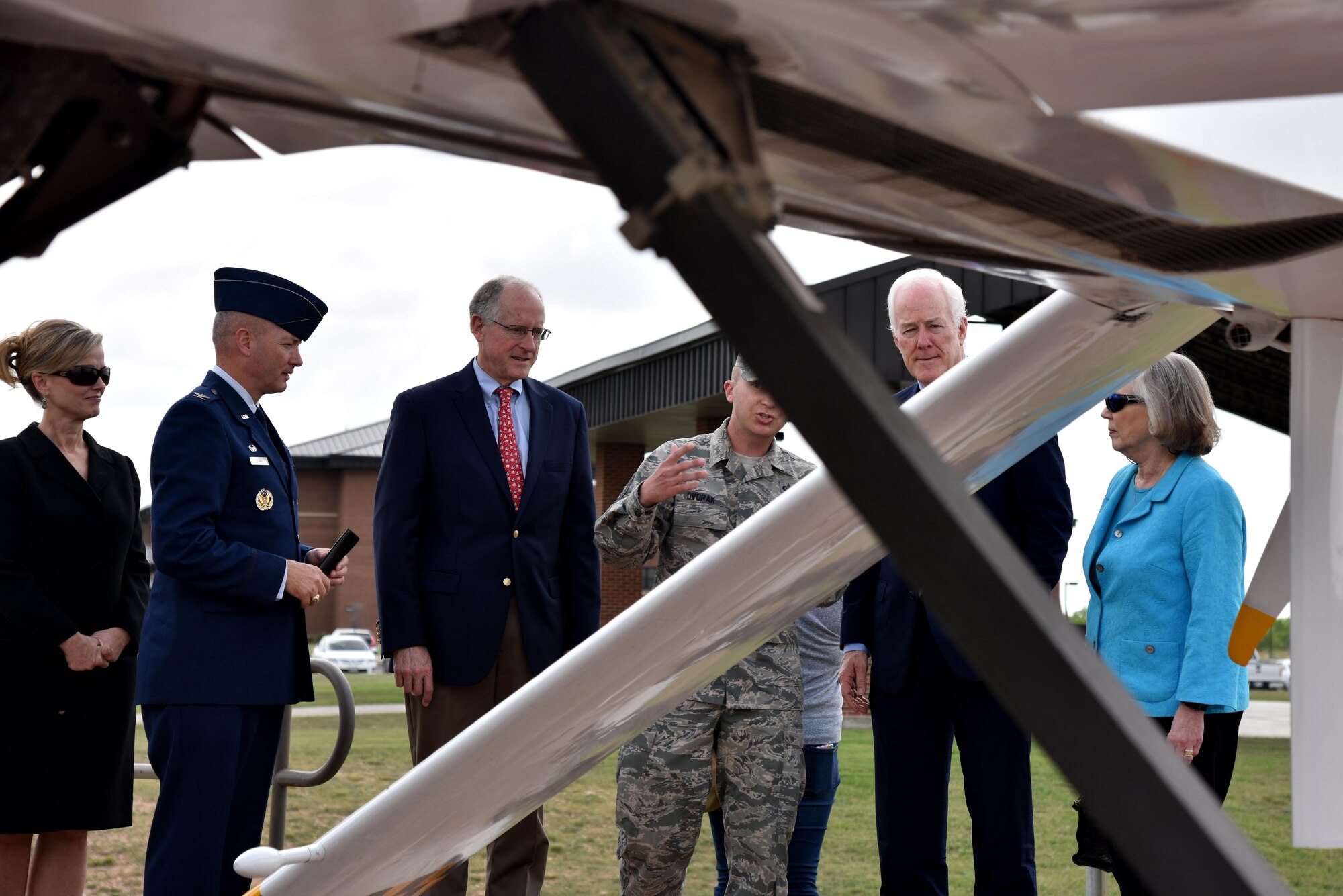U.S. Air Force Tech. Sgt. Aaron Dvorak, 315th Training Squadron geospatial intelligence analysis course chief, explains to Sen. John Cornyn III, Senate Majority Whip for the 115th Congress, the reason why we have a RQ-1 Predator aircraft display on Goodfellow Air Force Base, Texas, April 10, 2017. After his overview of the aircraft, Cornyn held a press conference. (U.S. Air Force photo by Staff Sgt. Joshua Edwards/Released)