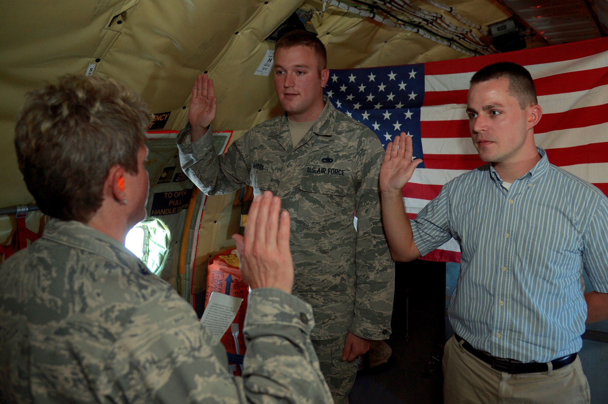 (Left to right) U.S. Air Force Col. Jennifer Crossman, vice wing commander of the 6th Air Mobility Wing, reenlists and enlists Staff Sgt. Corey Matera and his spouse, Travis Matera during a flight aboard a KC-135 Stratotanker aircraft enroute to Birmingham, Ala., April 4, 2017. Crossman, along with the wing’s command chief, operations group commander and superintendent, visited the Airmen of the 99th Air Refueling Squadron on Birmingham ANG Base to assess how they can better serve their Airmen serving in a geographically separated location.