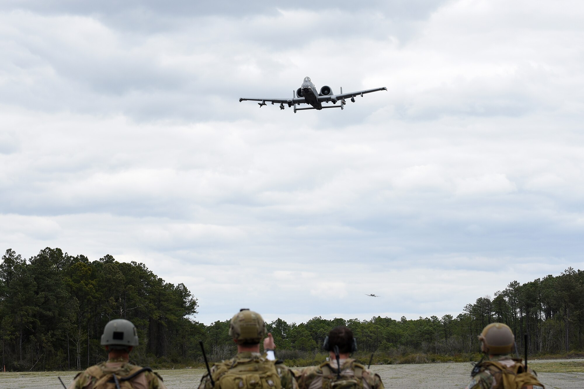 An A-10C Thunderbolt II flies over a group of tactical air control party specialists from the 14th Air Support Operations Squadron during exercise Razor Talon, April 7, 2017, at Atlantic Field Marine Corps Outlying Field, North Carolina. More than 10 aircraft from multiple bases participated in Razor Talon. (U.S. Air Force photo by Airman 1st Class Kenneth Boyton)