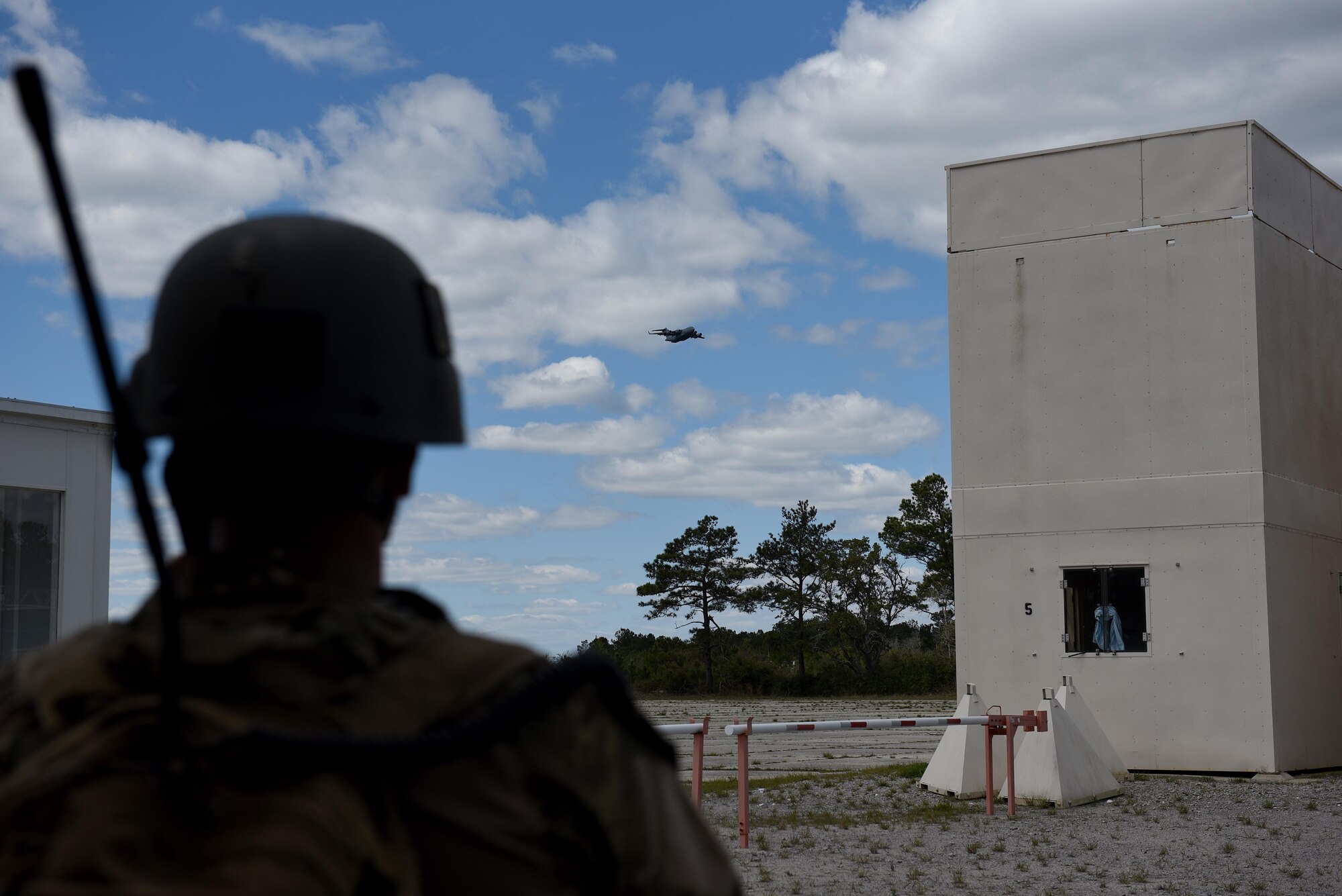Airman 1st Class Cody Ambrose, 14th Air Support Operations Squadron tactical air control party, watches a C-17 Globemaster III simulate an airdrop during exercise Razor Talon, April 7, 2017, at Atlantic Field Marine Corps Outlying Field, North Carolina. Razor Talon is a monthly joint-force exercise that combines resources from multiple installations across the East Coast and is designed to integrate air, land and sea forces to promote a more cohesive atmosphere between the different military services. (U.S. Air Force photo by Airman 1st Class Kenneth Boyton)