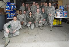 Airmen from the 301st and 381st intelligence squadrons pose for the camera after donating close to 4,000 items of canned food and other family needs to the Armed Service YMCA of Alaska at Joint Base Elmendorf-Richardson, Alaska, April 6, 2017. The two squadrons had a friendly competition to donate the most. 