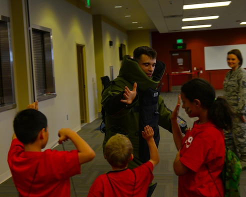 Airman 1st Class George Green, an explosive ordinance disposal technician assigned to the 28th Civil Engineer Squadron, congratulates children participating in the Kid’s Deployment Line at the deployment center at Ellsworth Air Force Base, S.D., April 8, 2017. The Kids Deployment Line was a part of the Month of the Military Child, and was planned by the Airman and Family Readiness Center and the Youth Center. (U.S. Air Force photo by Airman Nicolas Z. Erwin)