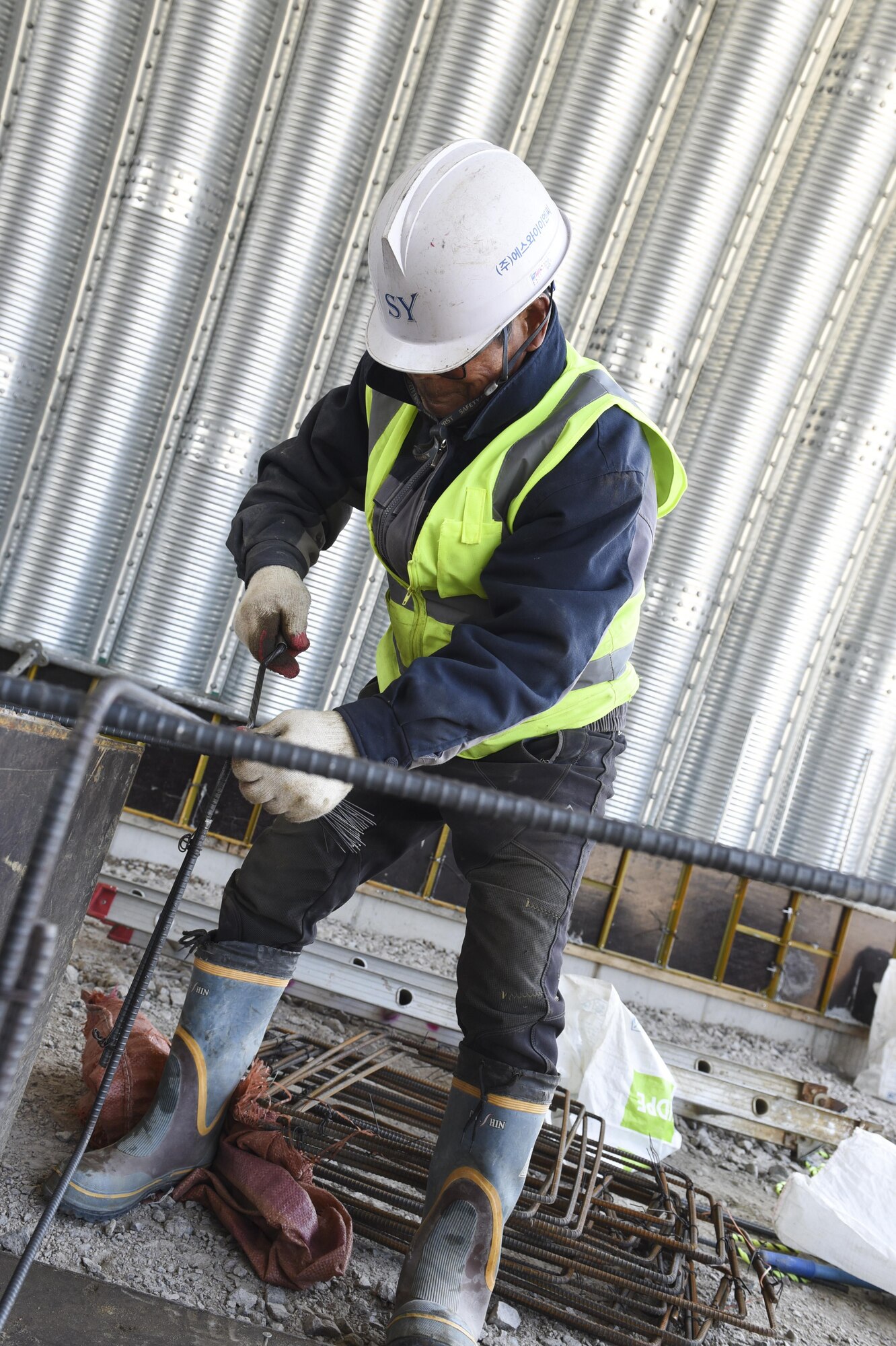 A Republic of Korea contractor ties rebar together in a flow-through shelter at Kunsan Air Base, Republic of Korea, March 21, 2017. The rebar will be used in the construction of more flow-through shelters for the 35th Fighter Squadron at Kunsan. (U.S. Air Force photo by Senior Airman Michael Hunsaker/Released)