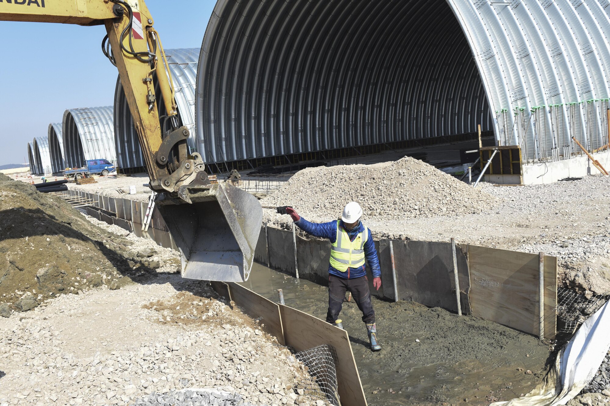 Mun Sung-Hwan, Republic of Korea contractor, guides an excavator bucket into a trench at Kunsan Air Base, Republic of Korea, March 21, 2017. Local contractors were brought to Kunsan to build new aircraft flow-through shelters. These shelters provide a protected area for aircraft to receive fuel and maintenance as quickly as possible during operations. (U.S. Air Force photo by Senior Airman Michael Hunsaker/Released)