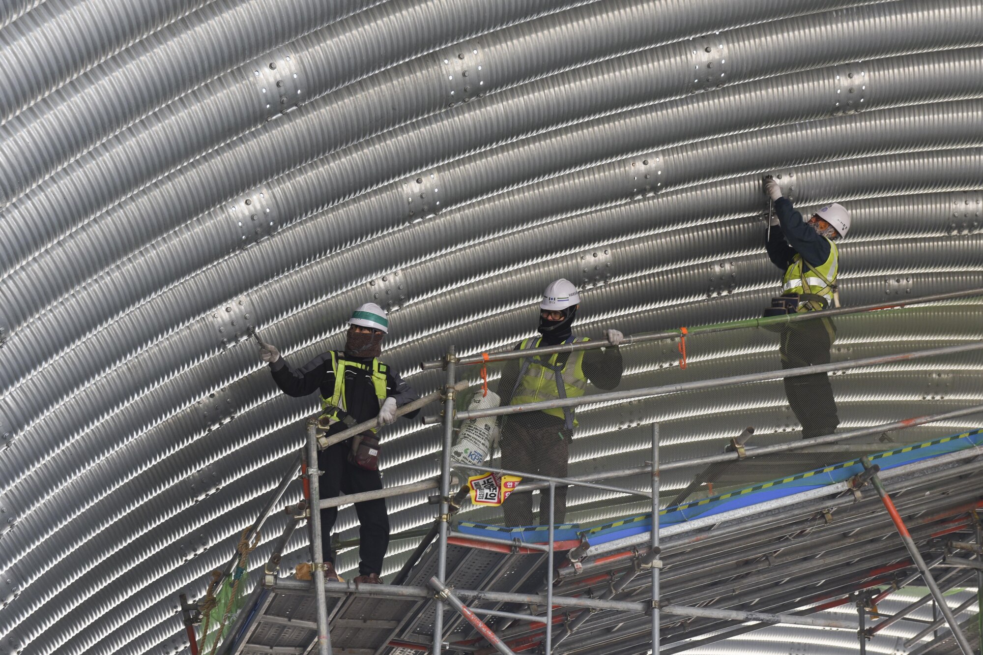 Republic of Korea contractors tighten bolts on an aircraft shelter at Kunsan Air Base, Republic of Korea, March 21, 2017.  These shelters provide a protected area for aircraft to receive fuel and maintenance as quickly as possible during operations. (U.S. Air Force photo by Senior Airman Michael Hunsaker/Released)