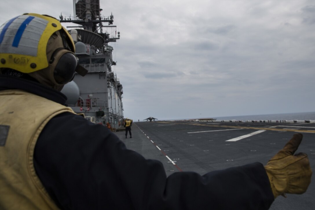 A Sailor signals to the pilot of an AV-8B Harrier during flight operations in the Pacific Ocean aboard the USS Bonhomme Richard (LHD 6), March 9, 2017. Marines and Sailors of the 31st MEU embarked aboard the USS Bonhomme Richard (LHD 6), part of the Bonhomme Richard Amphibious Readiness Group, as part of their annual spring patrol of the Indo-Asia-Pacific region. The 31st MEU, embarked on the amphibious ships of the Expeditionary Strike Group 7, has the capability to respond to any crisis or contingency at a moment’s notice. (U.S. Marine Corps photo by Cpl. Jona R. Meme) 