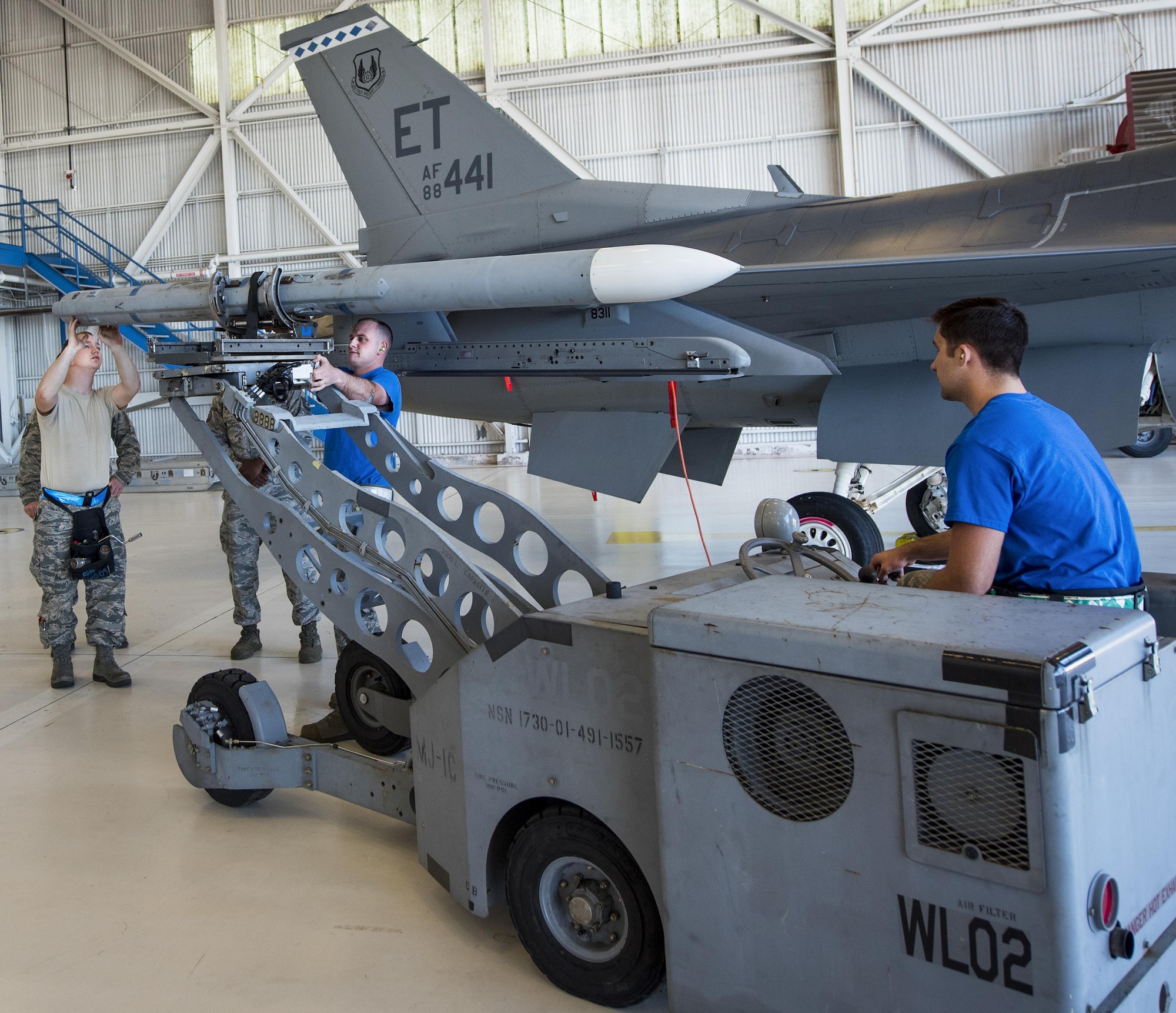 The 96th Aircraft Maintenance Squadron Blue team loads an AIM-120 missile onto their F-16 during the Team Eglin weapons load competition April 7 at Eglin Air Force Base, Fla.  Teams from the 96th Test Wing and 33rd Fighter Wing competed to see who could load up two weapons onto their designated aircraft the quickest and with the fewest errors.  The 33rd FW team repeated as base champion.  (U.S. Air Force photo/Samuel King Jr.)