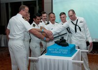 170331-N-XP344-0074 MANAMA, Bahrain (March 31, 2017) Sailors attending the 117th Submarine Ball team up to cut the cake at the Diplomat Radisson Blu in Manama, Bahrain. Cutting the cake is, from left, Lt. Cmdr. Rustin Dozeman, assigned to U.S. Naval Forces Central Command and the most senior submariner in attendance, Rear Adm. Richard A. Correll, the commander of Submarine Group 7, Task Force (TF) 54 and TF 74, and five USS Jacksonville (SS 699) Sailors who had their submarine warfares pinned that night. (U.S. Navy photo by Mass Communication Specialist 2nd Class Victoria Kinney)