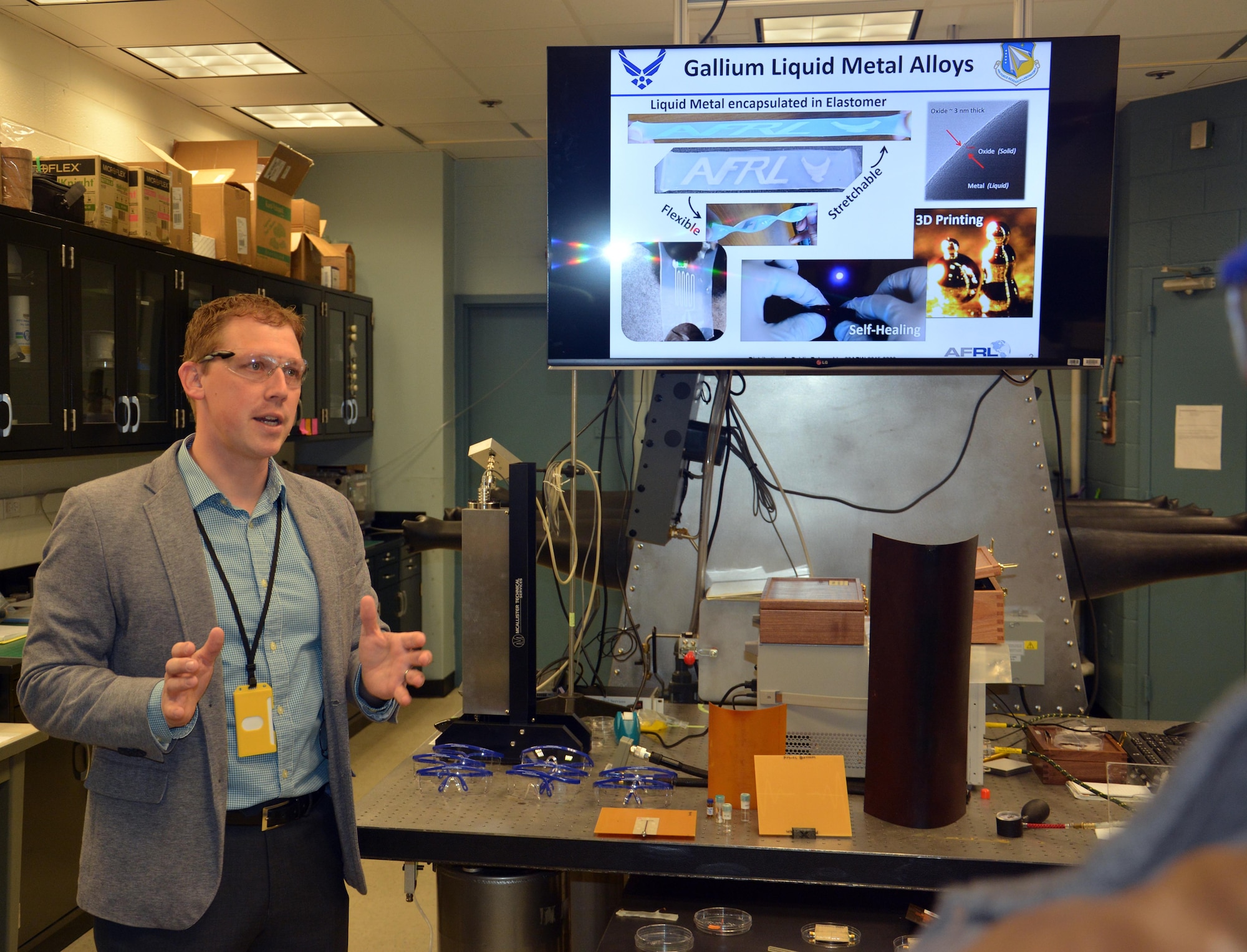 Dr. Christopher Tabor discusses potential applications of liquid metal alloys during the Materials and Manufacturing Directorate Open House, April 7. More than 200 guests, family members and friends of the laboratory participated in the inaugural Open House event, held in celebration of its 100 year anniversary this year. (U.S. Air Force photo/David Dixon)
