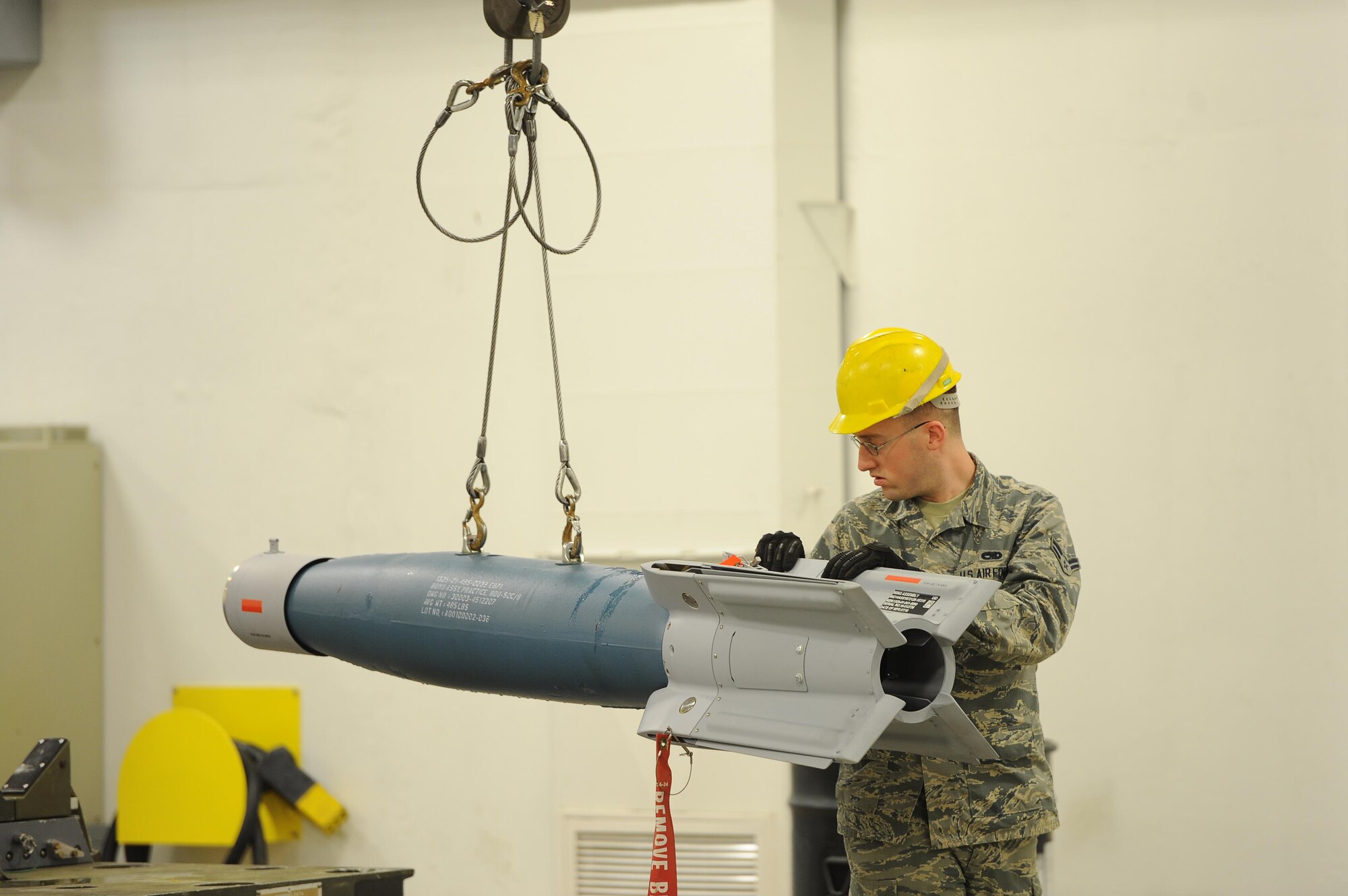 Airman 1st Class Stephen Walters, 5th Munitions Squadron conventional maintenance technician, guides an inert GBU-12 Bomb as it’s moved for maintenance at Minot Air Force Base, N.D., April 5, 2017. Situational awareness and teamwork is crucial for safe and effective transport of weapons systems on base. (U.S. Air Force photo/Senior Airman Kristoffer Kaubisch)