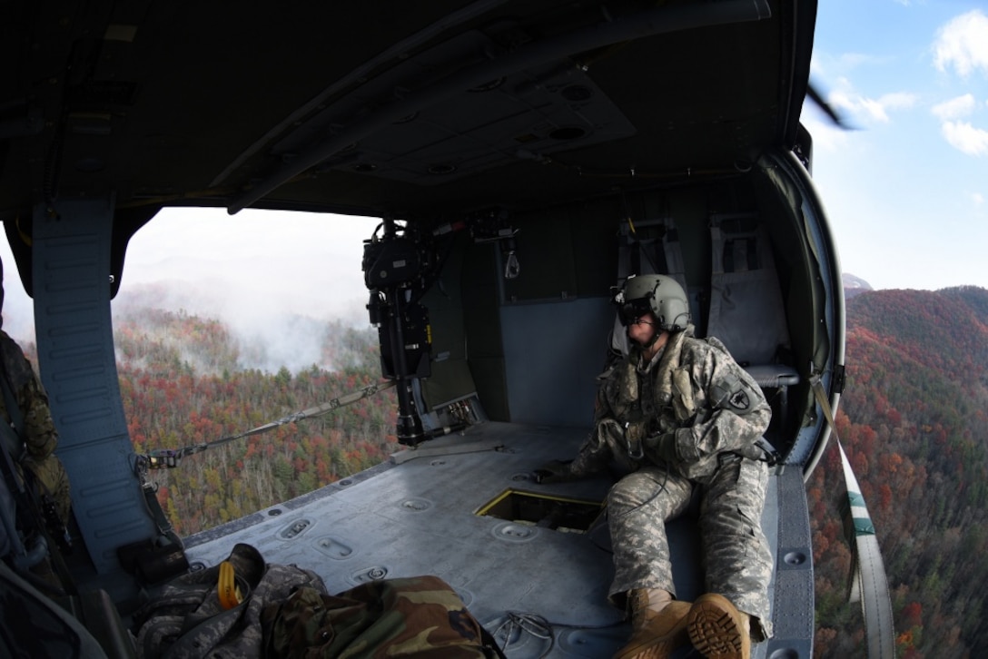 Army Staff Sgt. Jessica Thibeau, with the South Carolina Army National Guard’s 59th Aviation Troop Command, observes from a UH-60 Black Hawk helicopter during efforts to fight South Carolina wildfires, Nov. 24, 2016. South Carolina Army National Guard photo by Staff Sgt. Roberto Di Giovine