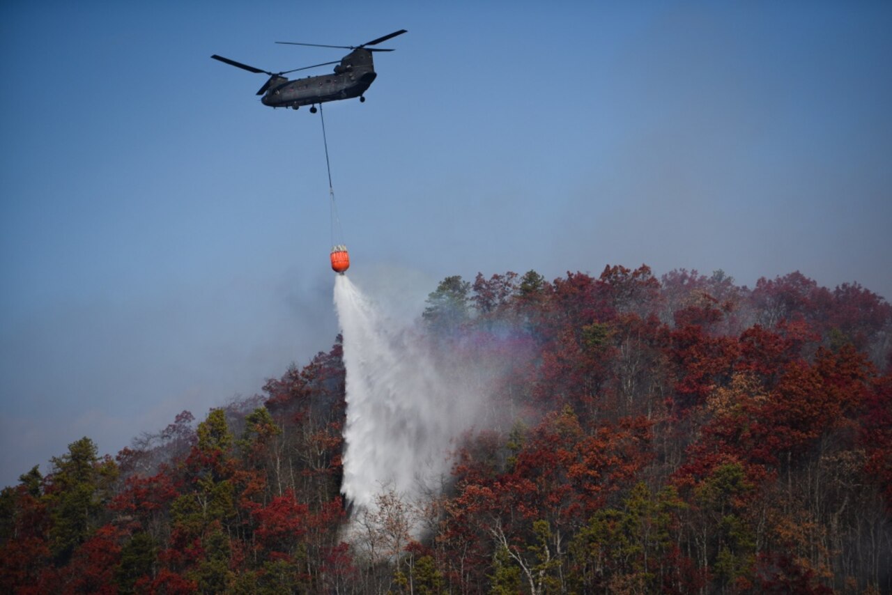 A CH-47 Chinook helicopter from the South Carolina Army National Guard’s 59th Aviation Troop Command drops water from a bucket firefighting system during efforts to fight South Carolina wildfires, Nov. 24, 2016. South Carolina Army National Guard photo by Staff Sgt. Roberto Di Giovine