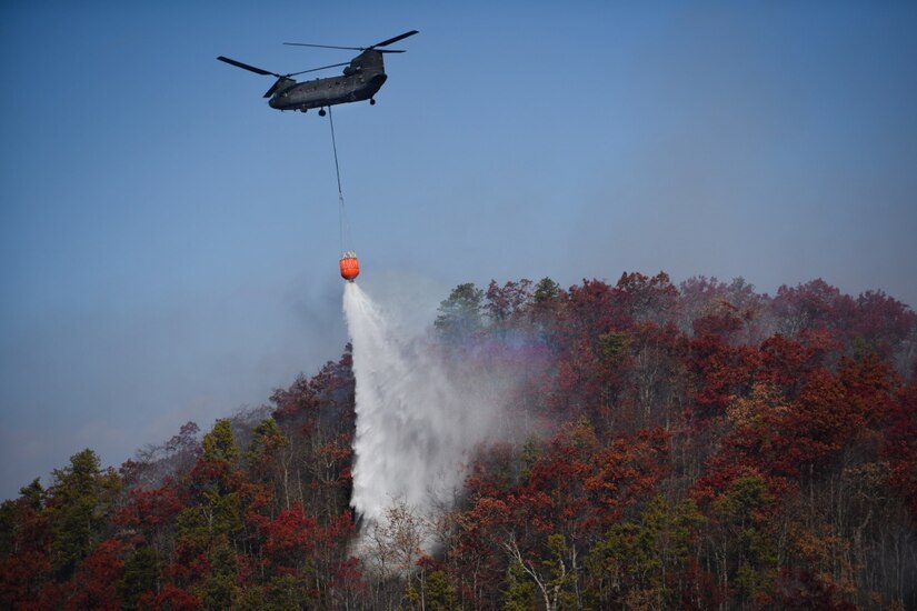 A CH-47 Chinook helicopter from the South Carolina Army National Guard’s 59th Aviation Troop Command drops water from a bucket firefighting system during efforts to fight South Carolina wildfires, Nov. 24, 2016. South Carolina Army National Guard photo by Staff Sgt. Roberto Di Giovine