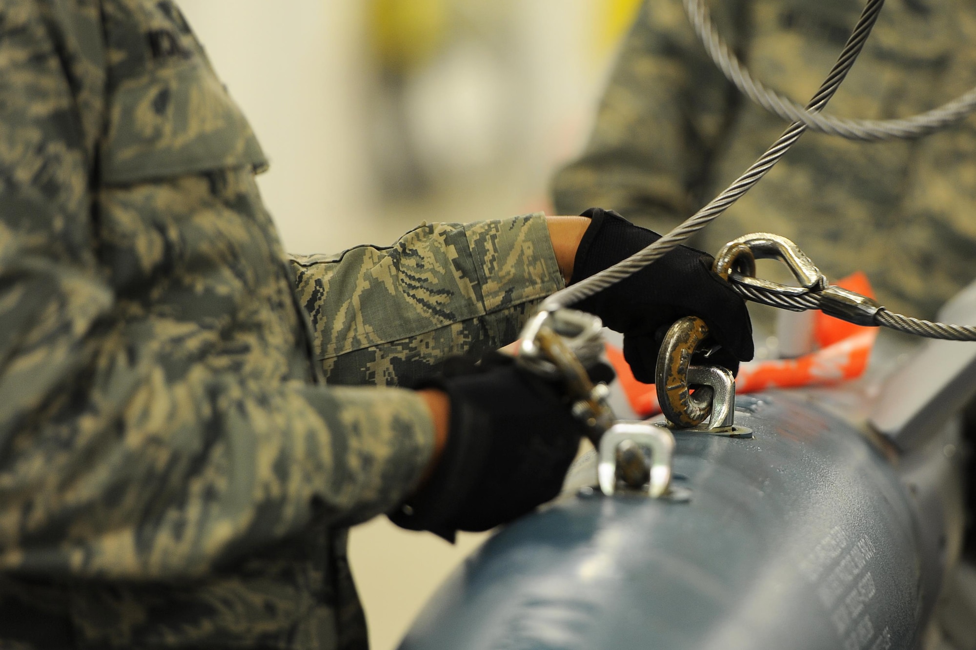 Airman 1st Class Brandon McMillan, 5th Munitions Squadron conventional maintenance technician, unhooks an inert GBU-12 bomb from an indoor crane and loads it onto a flatbed truck at Minot Air Force Base, N.D., April 5, 2017. Conventional maintenance crew members conduct familiarization and characteristic training to meet armor load standardizations. (U.S. Air Force photo/Senior Airman Kristoffer Kaubisch)