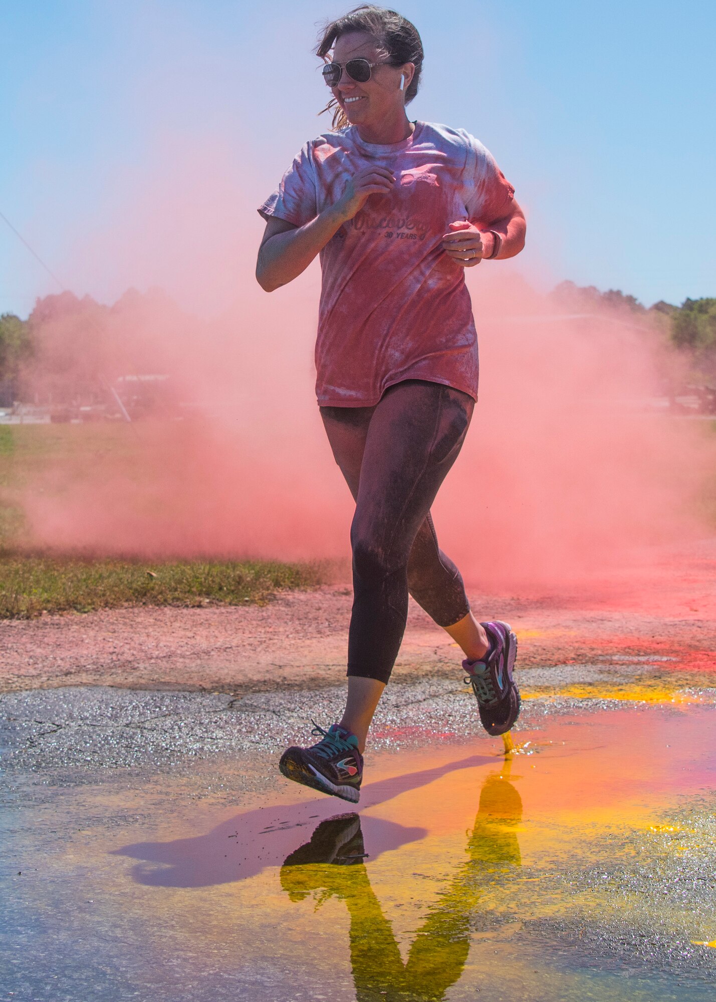 A runner moves through a pink cloud of powder toward the finish line during the 4th annual Color Me Aware Fun Run April 6 near the Civil Engineer Pavilion at Eglin Air Force Base, Fla. The run is held to raise sexual assault awareness. (U.S. Air Force photo/Ilka Cole) 