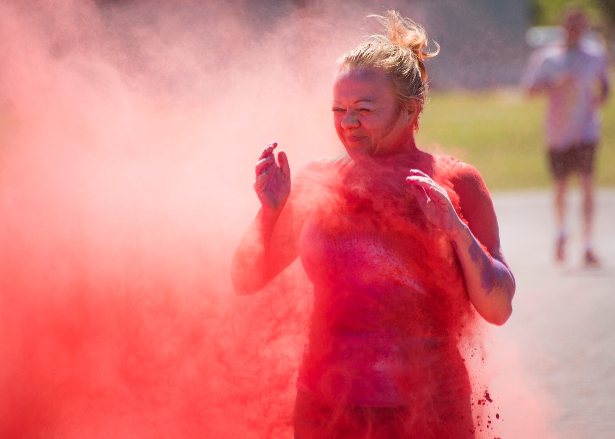 A runner squints through a pink cloud of powder during the 4th annual Color Me Aware Fun Run April 6 near the Civil Engineer Pavilion at Eglin Air Force Base, Fla. The run is held to raise sexual assault awareness. (U.S. Air Force photo/Ilka Cole) 