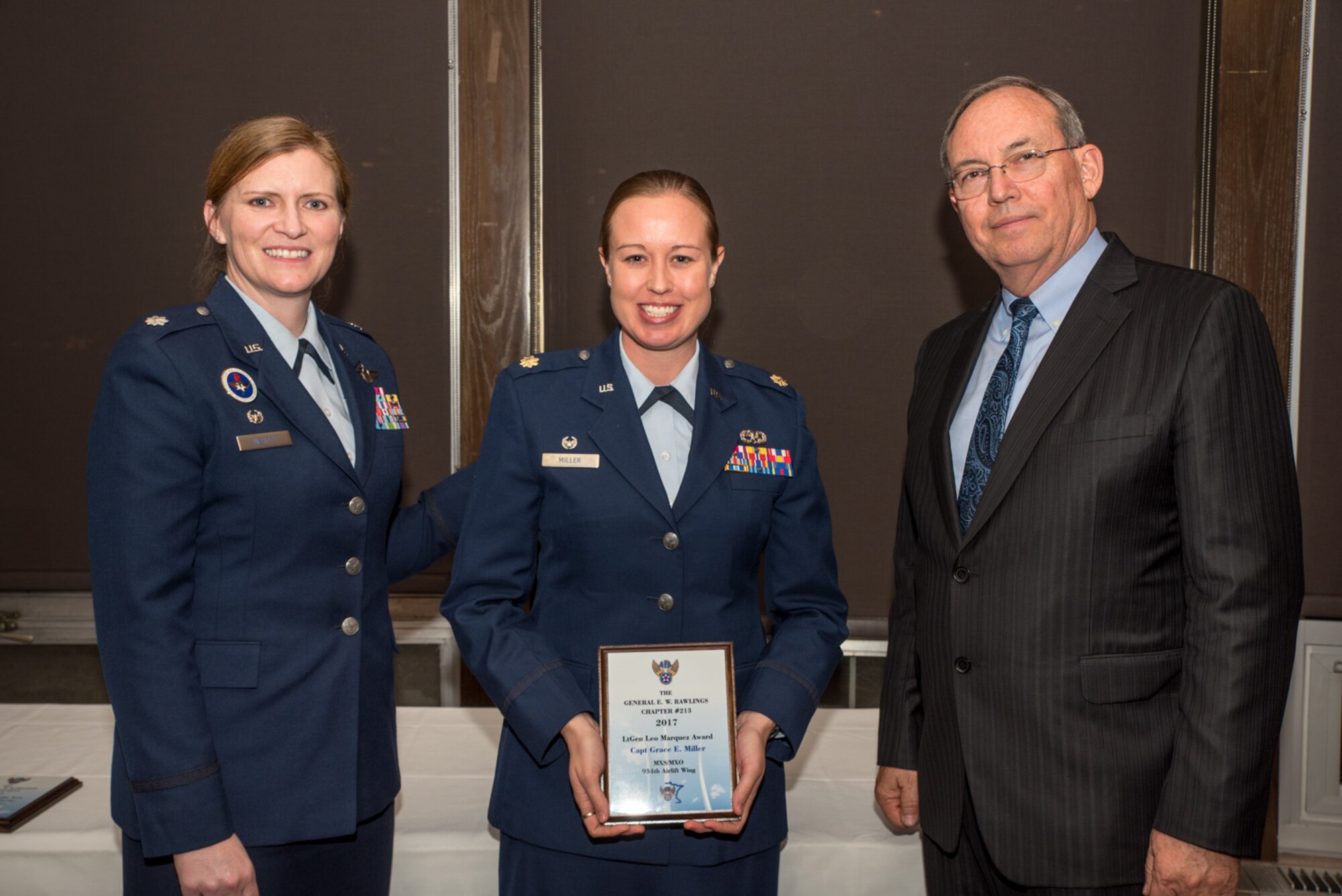 Lt. Col. Lizabeth Wenzel, commander of the Air Force ROTC Detachment 415 at the University of Minnesota, and retired Air Force Lt. Gen. David Deptula, dean of the Mitchell Institute for Aerospace Power Studies, present Maj. Grace Miller, the 934th Aircraft Maintenance Squadron commander, the Lt. Gen. Leo Marquez Award at the Air Force Association’s 2017 Awards Dinner sponsored by the General E. W. Rawlings Chapter, April 7 at the Town & Country Club in St. Paul, Minn. The Leo Marquez Award recognizes Air Force personnel for outstanding performance in areas like financial efficiency and managerial skills. (U.S. Air Force photo by Master Sgt. Eric Amidon)