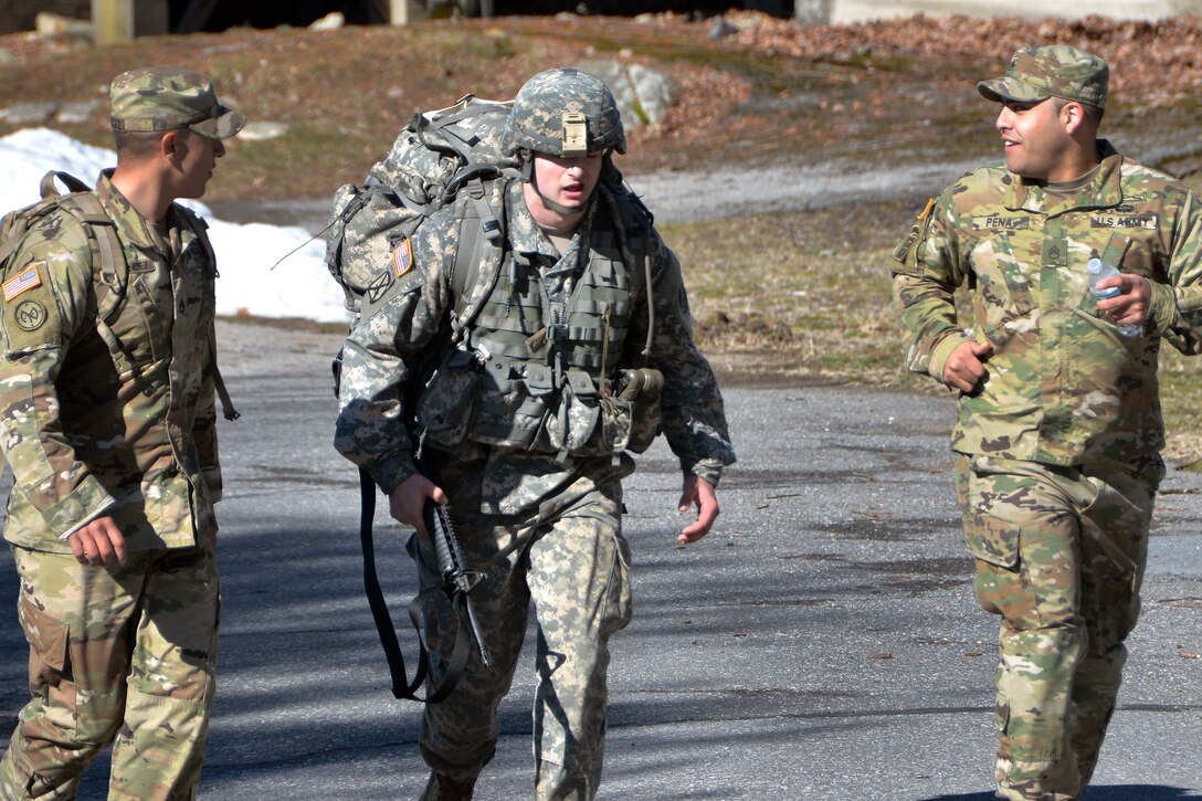 New York Army National Guard Sgt. Mitchell Stogel, center, finishes a 12-mile forced march to complete the New York Army National Guard Best Warrior Competition at Camp Smith, New York, April 2, 2017. Stogel is assigned to Headquarters Company, 1st Battalion, 69th Infantry Regiment. Army National Guard photo by Sgt. Maj. Corine Lombardo