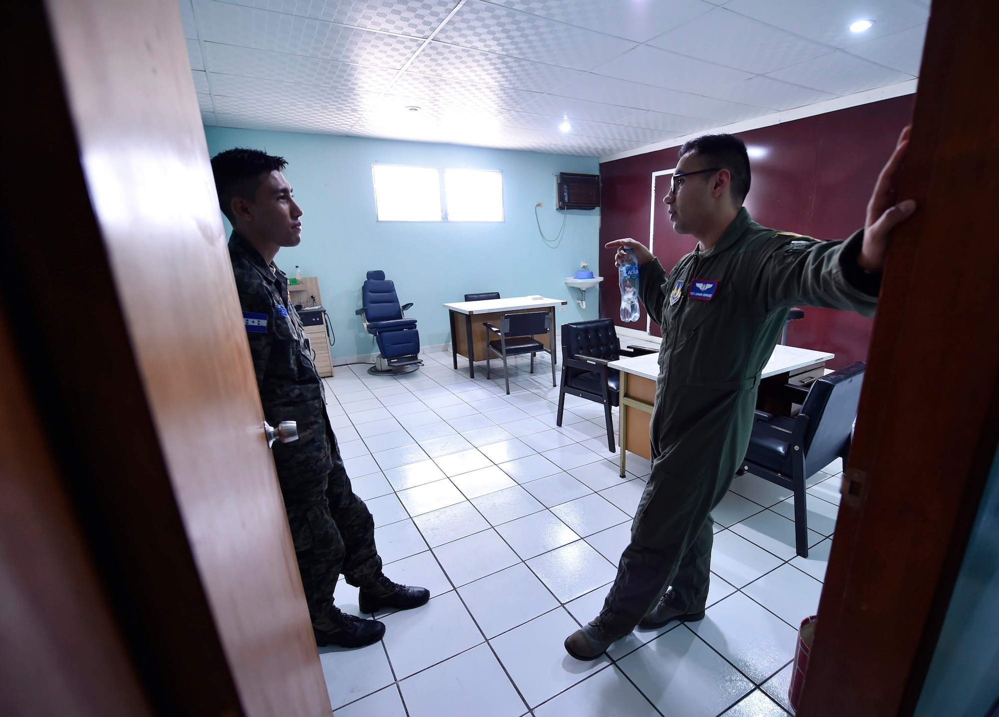 U.S. Air Force Tech. Sgt. Johann Bermudez, U.S. Air Force School of Aerospace Medicine aeromedical evacuation instructor, Wright-Patterson Air Force Base, Ohio, right, discusses aerospace medicine best practices with a member of the Honduran air force during a medical clinic tour as part of a subject matter expert exchange in Tegucigalpa, Honduras, April 4. The global health engagement brought U.S. and Honduran counterparts together to build and strengthen partner relationships.