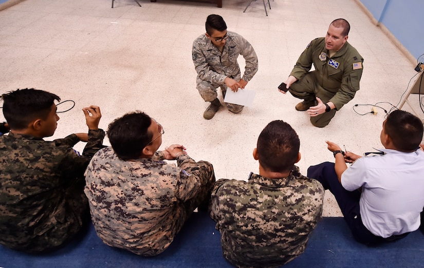 U.S. Air Force Staff Sgt. Gabriel Trujillo, 779th Medical Operations Squadron paramedic, Joint Base Andrews, Maryland, top left, and U.S. Air Force Capt. Diego Torres, Detachment 4, 375th Operations Group flight nurse instructor and evaluator, Wright-Patterson Air Force Base, Ohio, top right, talk about aerospace medicine best practices during a round table discussion as part of a subject matter expert knowledge exchange in Tegucigalpa, Honduras, April 5. The global health engagement brought U.S. and Honduran counterparts together to build and strengthen partner relationships.