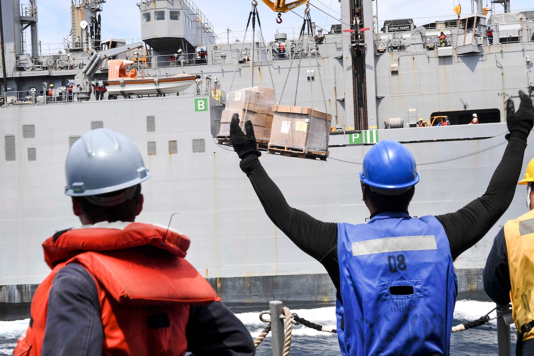 A sailor aboard the guided missile destroyer USS Wayne E. Meyer signals to the dry cargo ship USNS Cesar Chavez during an underway replenishment in the South China Sea, April 3, 2017. Navy photo by Petty Officer 3rd Class Kelsey L. Adams 