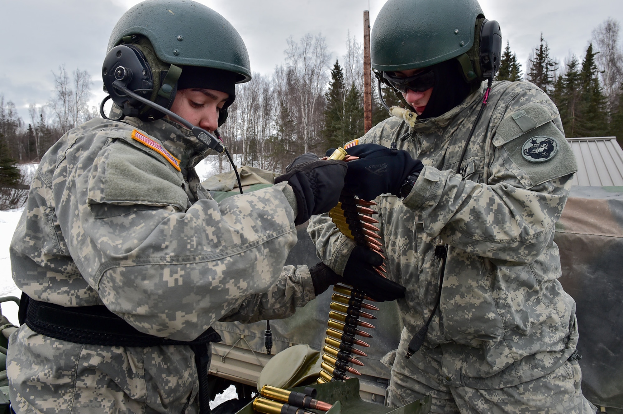 Army Sgt. Mayra Haynes, a native of Anaheim, Calif., left, and Army Pfc. Donald Mills, a native of Wallkill, N.Y., both assigned to the 95th Chemical Company, “Arctic Dragons”, 17th Combat Sustainment Support Battalion, U.S. Army Alaska, load .50 caliber ammunition at a supply point before a gunnery live-fire exercise with M1135 Stryker Nuclear Biological Chemical Reconnaissance Vehicles on Joint Base Elmendorf-Richardson, Alaska, April 5, 2017.  The gunnery tested Soldier’s proficiency with identifying, engaging, and eliminating hostile targets while increasing combat effectiveness. The Styker NBCRV provides Nuclear, Biological, and Chemical detection and surveillance for battlefield visualization, and situational awareness to increase unit combat power.  The core of the NBCRV is its on-board integrated NBC sensor suite, and integrated meteorological system.  An NBC positive overpressure system minimizes cross-contamination of samples and detection instruments, provides crew protection, and allows extended operation at Mission Oriented Protective Posture.