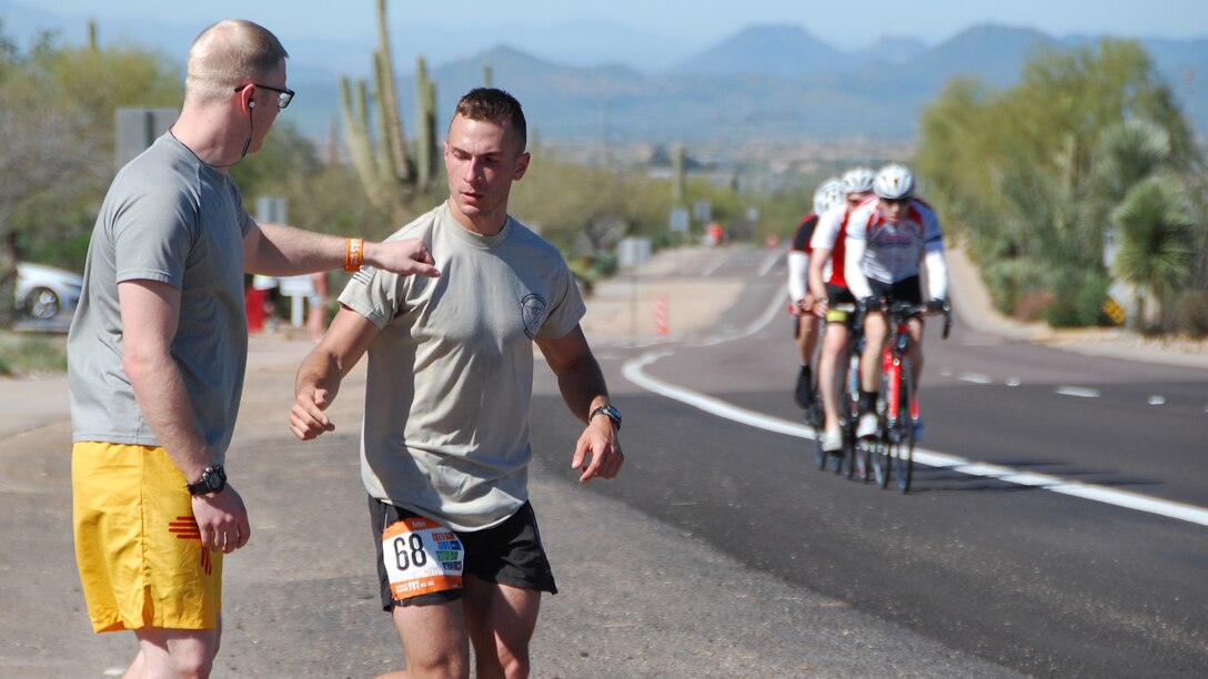 Senior Airman Zachary Benedetti, 58th Maintenance Squadron jet engine mechanic, places a wristband on Senior Airman Chris Ogle, 58th MXS aircraft structural maintenance specialist, during the Ragnar Del Sol relay race in Arizona March 11. When one runner’s leg ended, they would place the wristband on the next runner. 