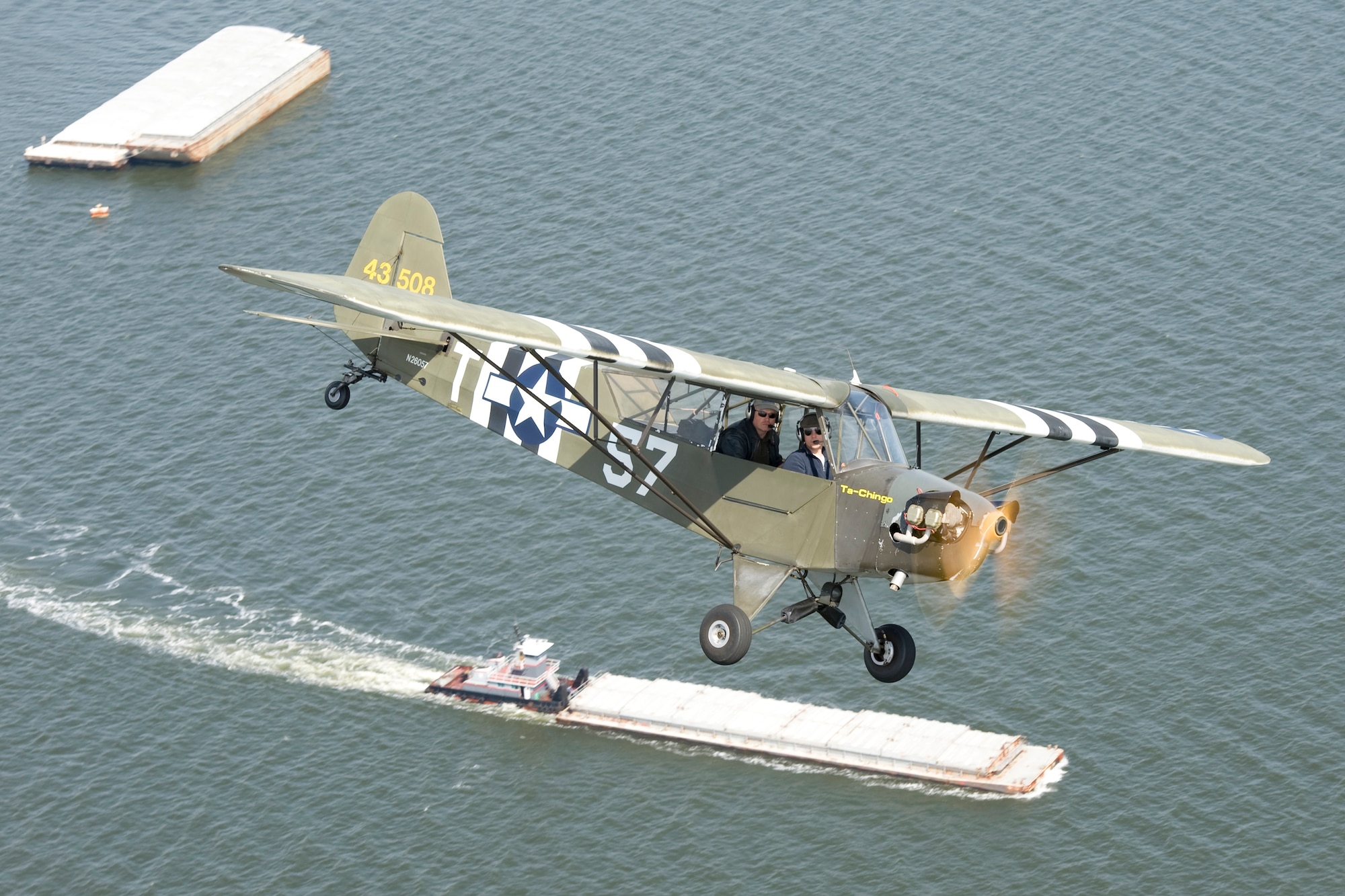 Aerial photo of a 1939 Piper J-3 'Cub,' N26057, piloted by Jeremy 'Silas' LeBons and Peter "Kos' Kosogorin, over Virgina waters near Hummell Field, Va., April 7, 2013. This aircraft, and many others like it, was pressed in to service with the military as an L-4 'Grasshopper' during World War II.  Courtesy photo/Greg L. Davis, Aviation Photojournalist.