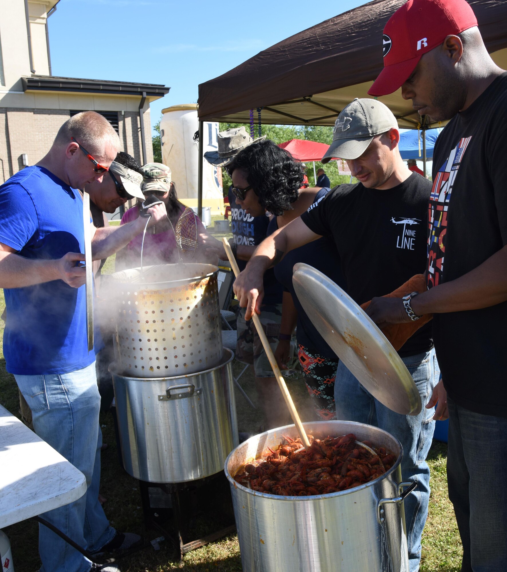 “Swamp Swimmers” team members lift freshly boiled crawfish from a pot during the 5th Annual Bay Breeze Crawfish Cook-Off at the Bay Breeze Event Center April 7, 2017, on Keesler Air Force Base, Miss. The “Keesler Chiefs” won first place overall and a free entry into the 25th Annual Mississippi Coast Coliseum Crawfish Festival Cook-Off. (U.S. Air Force photo by Kemberly Groue)