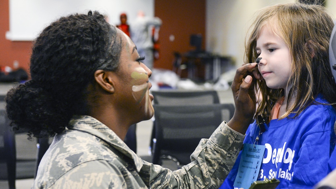 Air Force Airman 1st Class Deja Hunter paints the nose of a child going through the Kids Deployment Line during a Month of the Military Child event at Ellsworth Air Force Base, S.D., April 8, 2017. Air Force photo by Airman Nicolas Z. Erwin